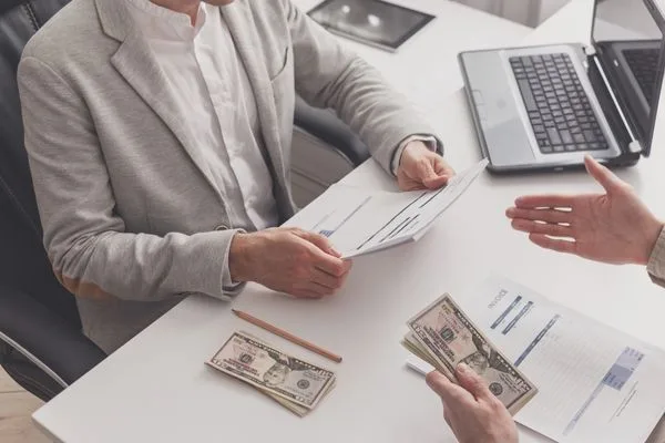 Cliente completando el proceso de cobro de cheques en una oficina financiera
