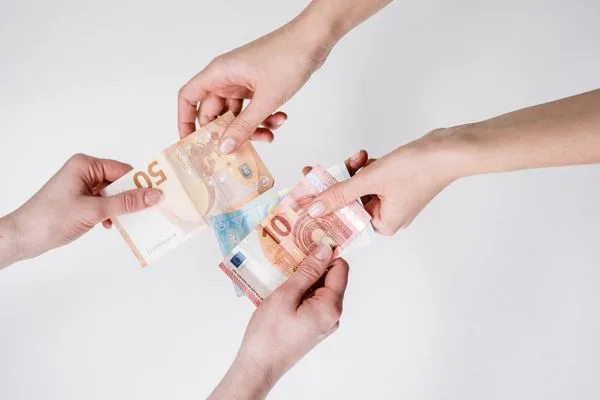 Hands exchanging euro bills during check cashing process