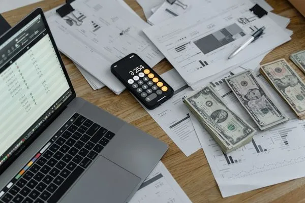 Money Order Accounting With Laptop Calculator And Cash Bills