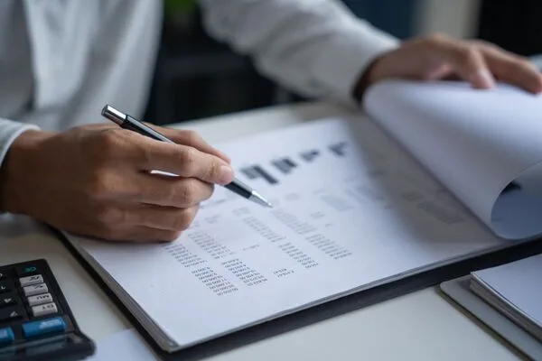 Businessman reviewing financial documents related to Money Order processing.
