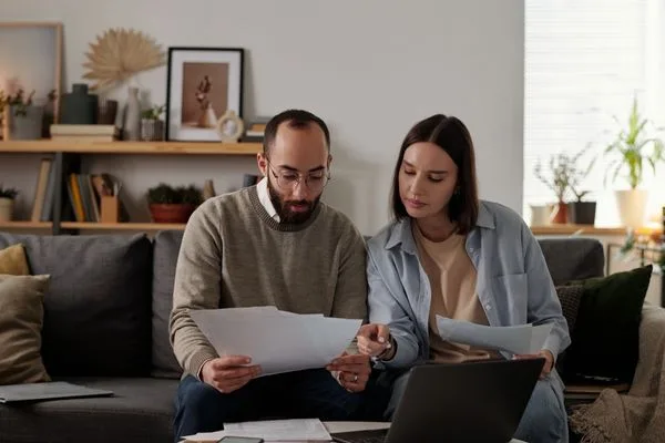 Couple reviewing Money Order documents together at home office.