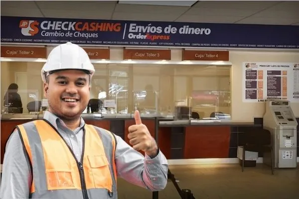 Trabajador de la construcción sonriendo dentro de un local de cambio de cheques