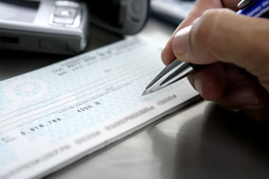 Persona escribiendo un cheque