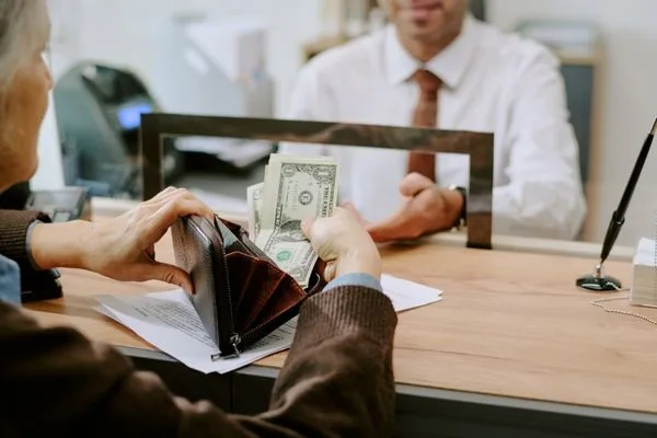 Cliente preparando efectivo para una transacción de transferencia de dinero segura
