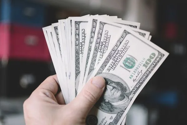 Hand Holding Cash For Secure Check Cashing Transaction