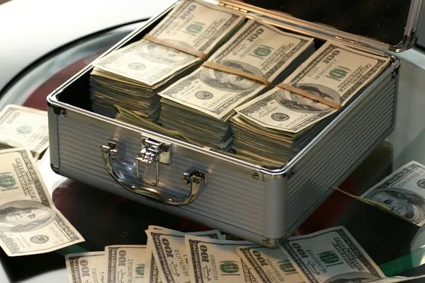 Fajos de billetes en un maletín que representan el cumplimiento de las normas de cobro de cheques