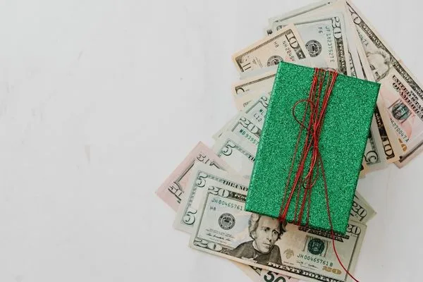 Regalo envuelto con dinero que simboliza el cobro de cheques en temporada