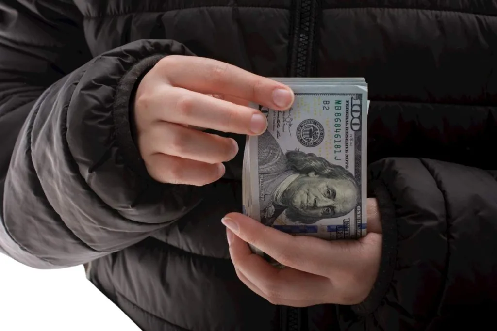 Manos sosteniendo efectivo durante una transferencia de dinero segura
