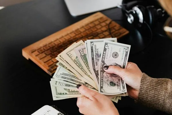 Transferencia de dinero en efectivo contada a mano en el escritorio de la oficina