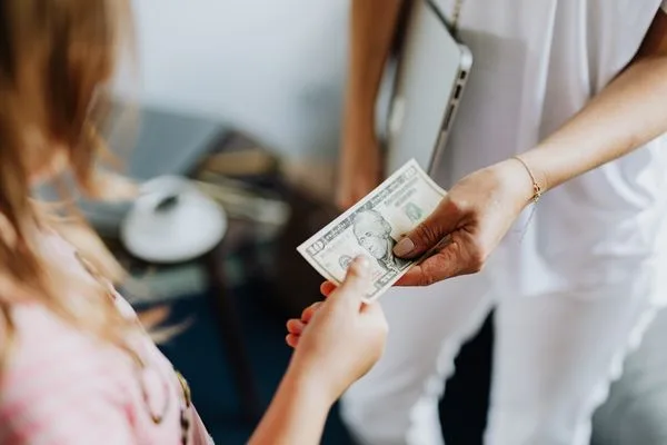 Manos intercambiando efectivo para representar una transferencia de dinero