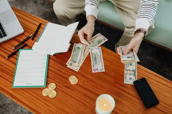 Person Organizing Cash And Notes For Money Transfer Planning