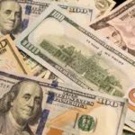 Transferencia de dinero representada por billetes de dólares estadounidenses en primer plano