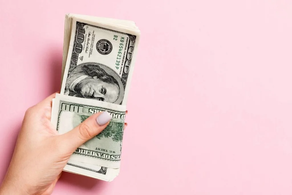 Mano sosteniendo dinero en efectivo como símbolo de un servicio seguro de cambio de divisas