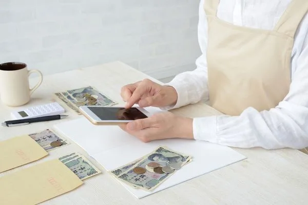 Person Using Mobile Phone During Currency Exchange Cash Review