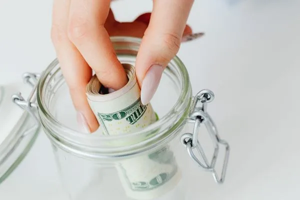 Saving cash in glass jar for future money transfer