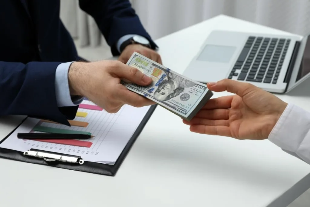 Manos intercambiando dinero durante un proceso de cobro de cheques