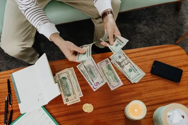 Cash handling during Money Transfer planning on wooden desk