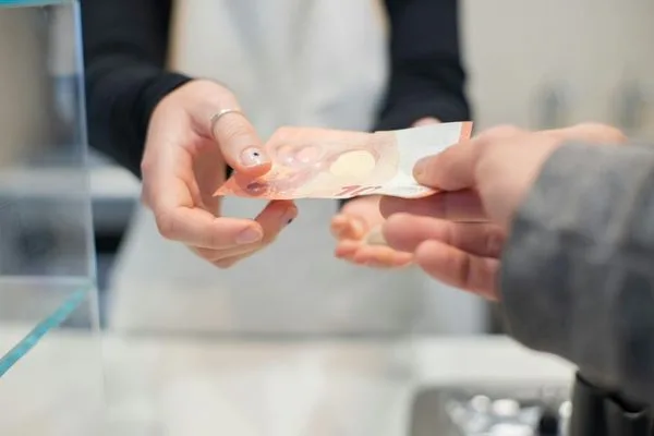 Cliente entregando dinero durante el servicio de cambio de cheques