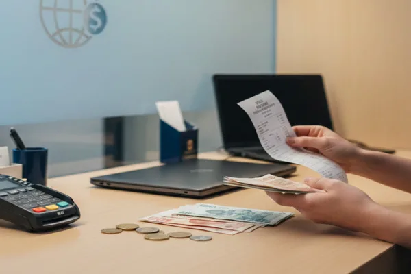 Cliente contando efectivo después de una transacción de cambio de divisas
