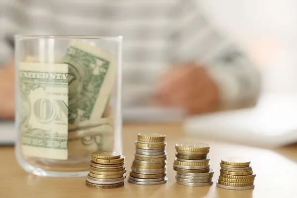 Tarro de ahorros y monedas para planificar el cambio de divisas