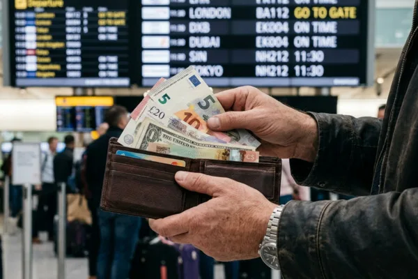 Viajero contando efectivo internacional para el cambio de divisas
