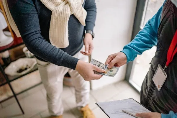 Customer Completing Money Transfer With Cash Payment