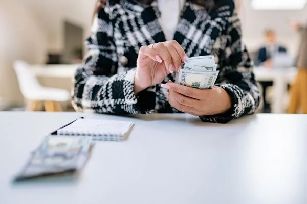 Customer Handling Cash At Retail Currency Exchange Counter