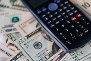 Cálculo del cambio de divisas con billetes de dólar y calculadora