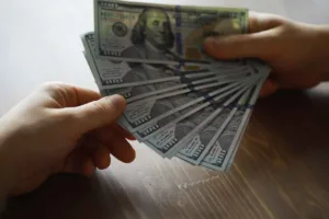 Cambio de divisas: Conteo manual de billetes de dólares estadounidenses