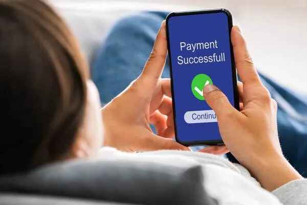 una mujer realiza una transferencia de dinero con su teléfono
