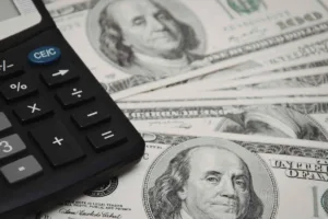 Calculadora de cambio de divisas con billetes de dólar estadounidense en primer plano