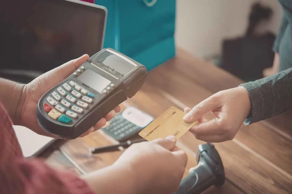 Cliente utilizando terminal de tarjeta en caja de cambio de divisas