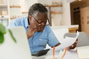 Hombre revisando documentos para cambio de divisas en su escritorio en casa