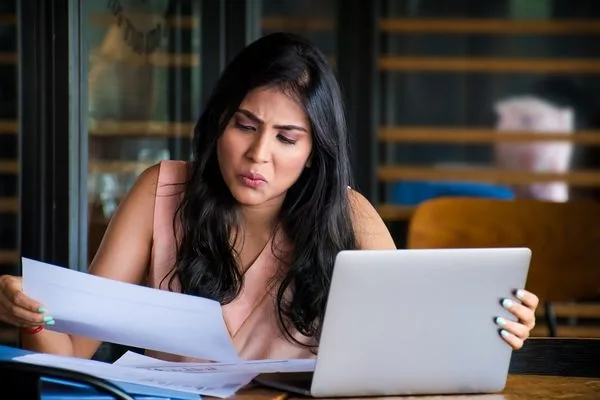 Mujer revisando billetes y documentos para cambio de divisas