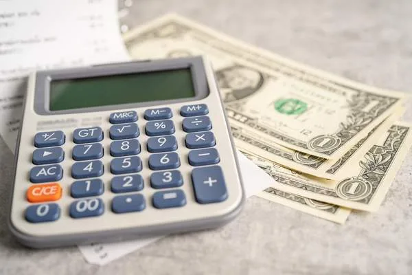 Estimación de las comisiones por cobro de cheques con calculadora y efectivo