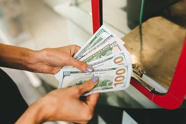 Currency Exchange Customer Counting U.S. Dollars At Counter