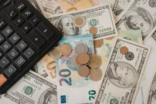 Tipos de cambio mostrados con efectivo internacional y calculadora.