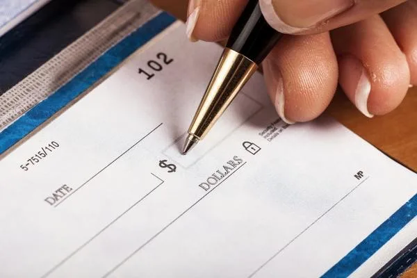 Filling out a check before completing a financial transaction